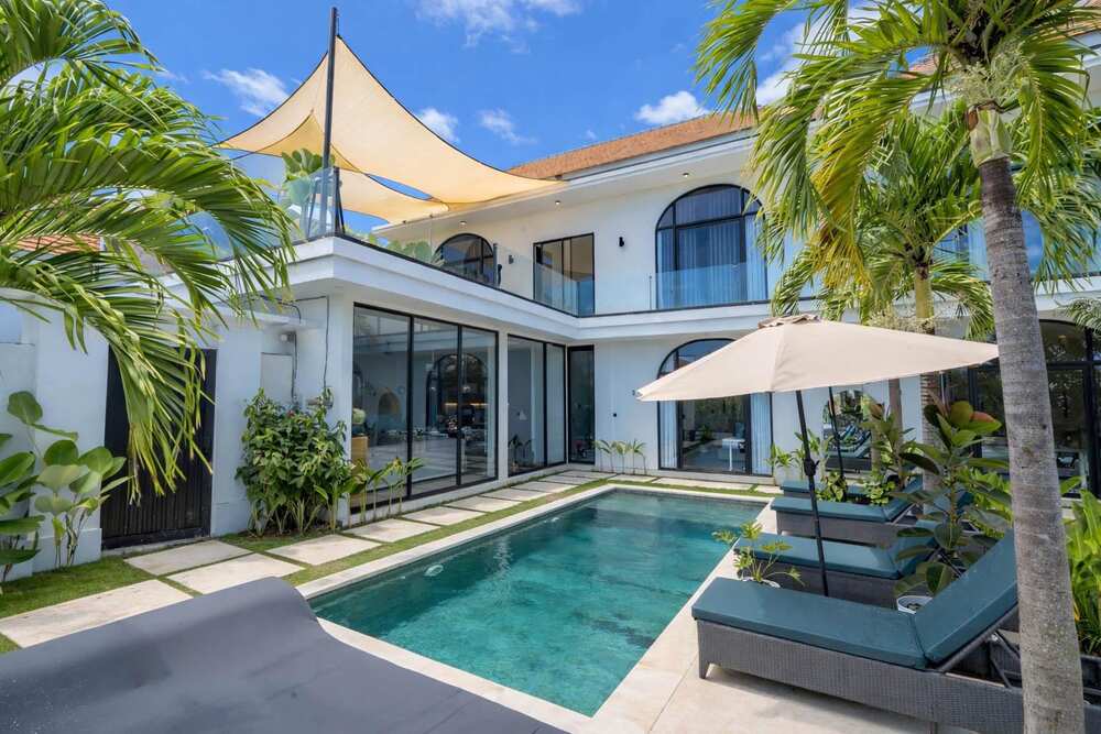 Bali founder house pool and villa exterior with palm trees
